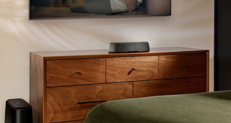 Compact soundbar sitting on a dresser.